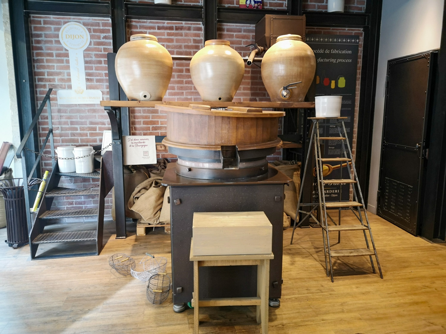 Strumenti e vasi per produrre e conservare la senape all'interno del negozio Moutarderie Edmond Fallot di Digione