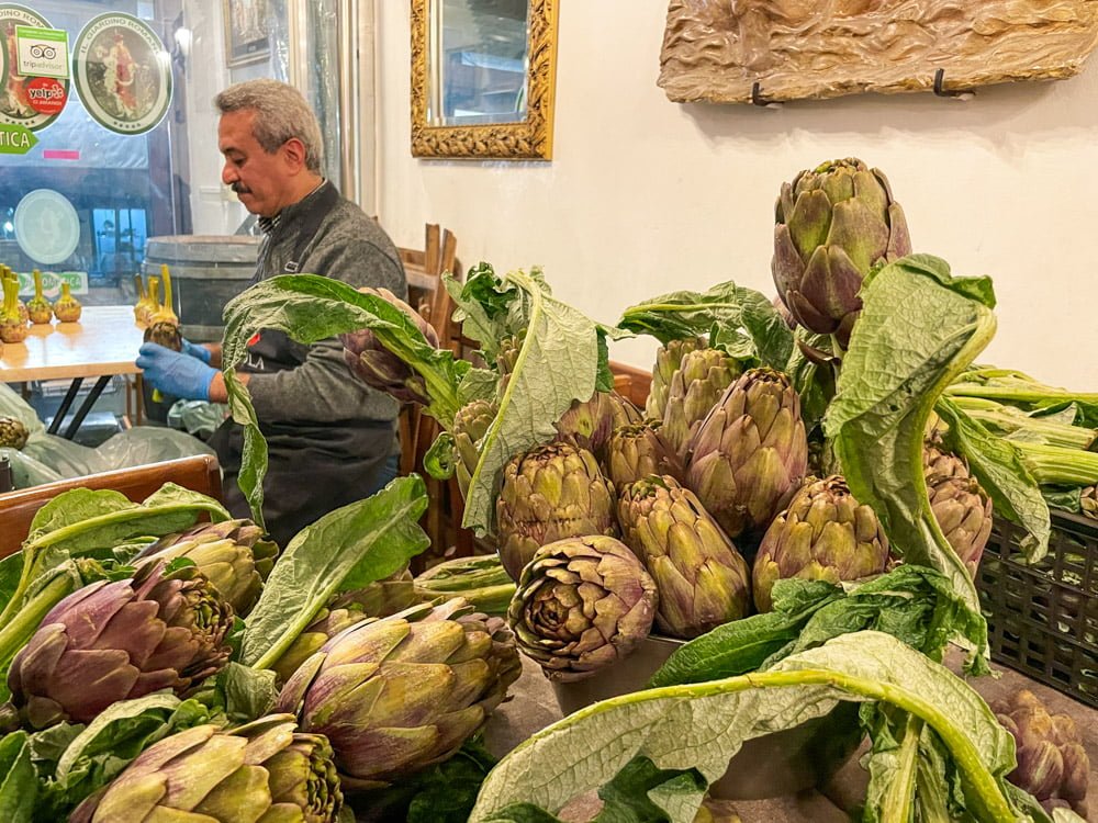 Il sig. Giuseppe, uno dei titolari del ristorante Il Giardino Romano che pulisce i carciofi per cucinarli secondo le ricette tradizionali romane ed ebraiche