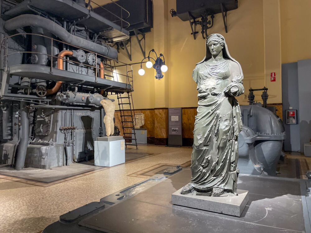 Statua romana e macchinario moderno al museo Centrale Montemartini a Roma