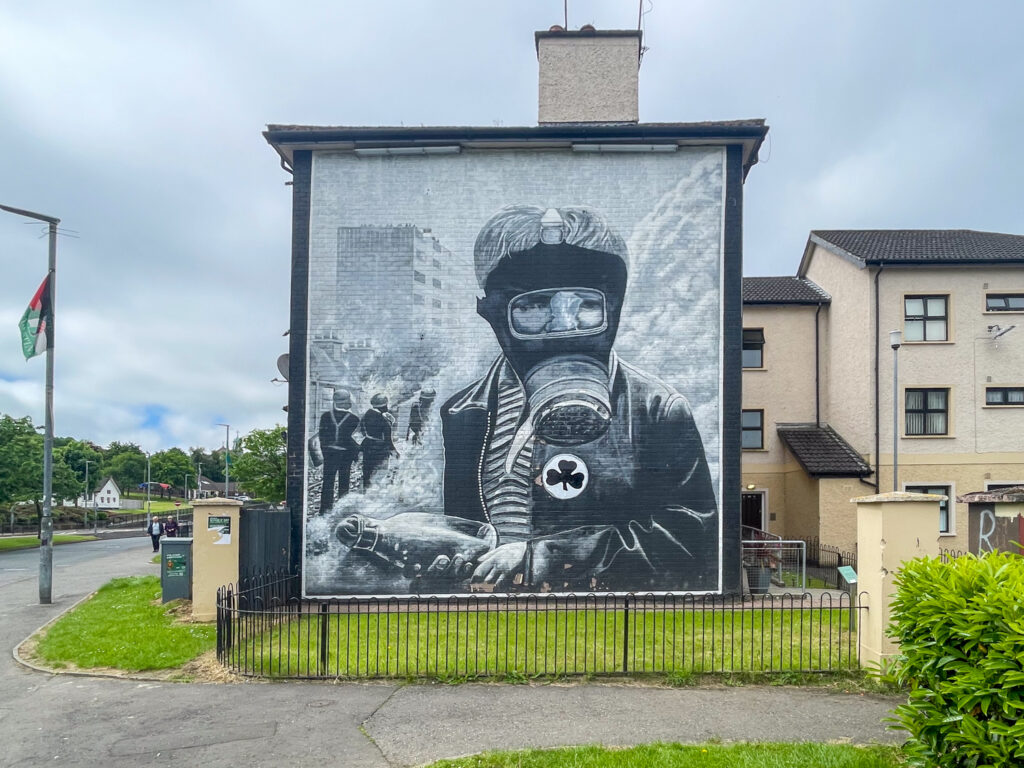 Murale nell'area di Bogside raffigurante un manifestante che indossa una maschera antigas, Derry