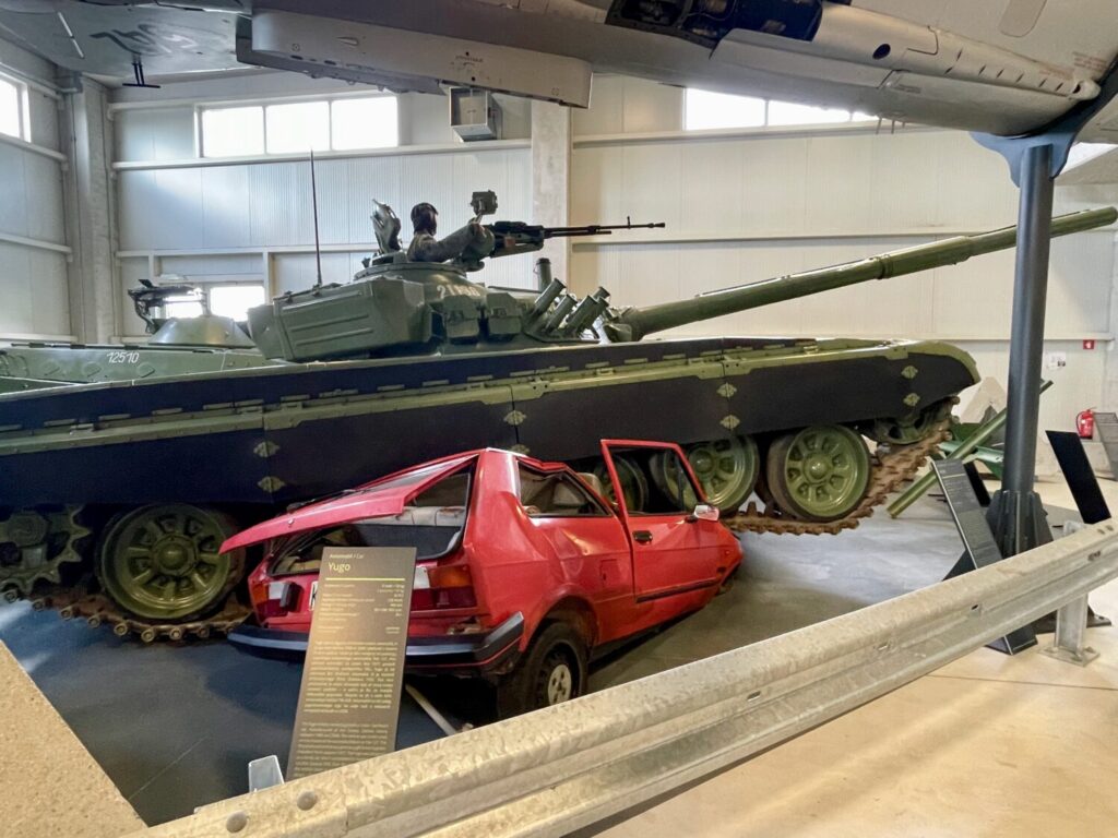 Carro armato jugoslavo schiaccia auto Yugo rossa al Museo della Storia Militare di Pivka, in Slovenia