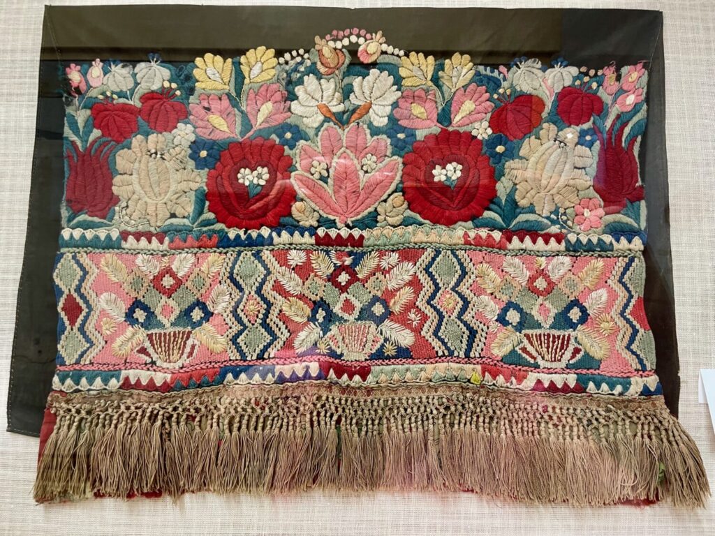 Tessuto ricamato in stile matyó (sopra) e írásos (sotto), esposto al Museo Matyó di Mezőkövesd
