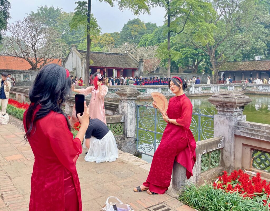 Ragazze vietnamite si fanno fotografare in abito tradizionale al Tempio della Letteratura di Hanoi