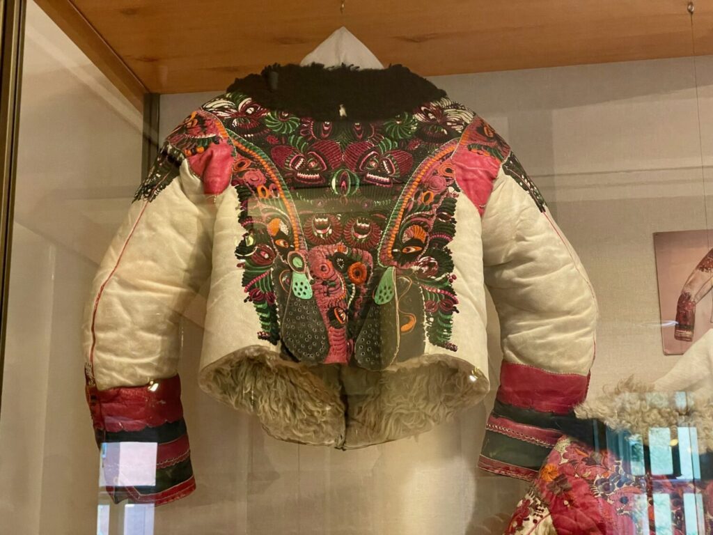 Giacca in pelle di pecora riccamente decorata con motivi Matyó colorati al Museo Matyó di Mezőkövesd