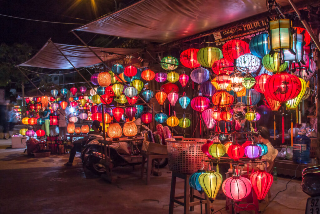 Negozi di souvenir di sera con lanterne illuminate a Hoi An, Vietnam