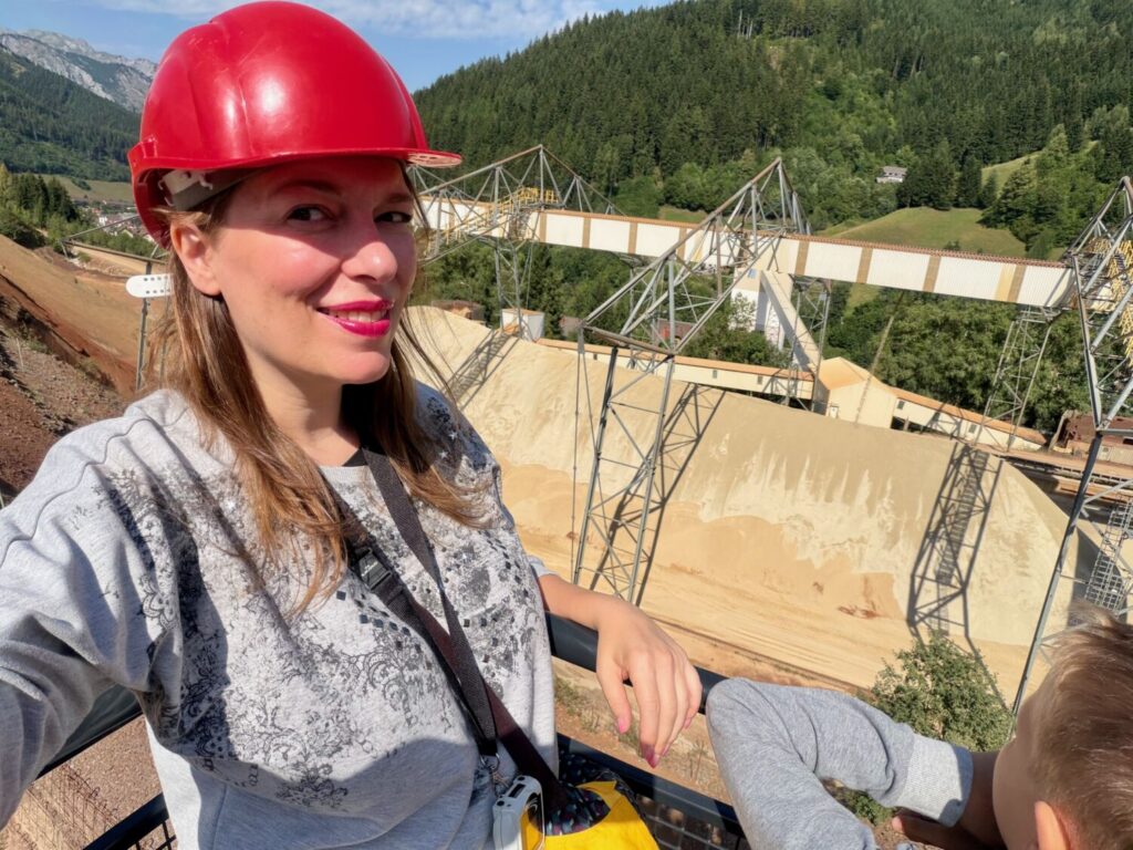 Paola Bertoni con caschetto protettivo sulla piattaforma panoramica del camion da cava Hauly alla Miniera di Erzberg, Austria
