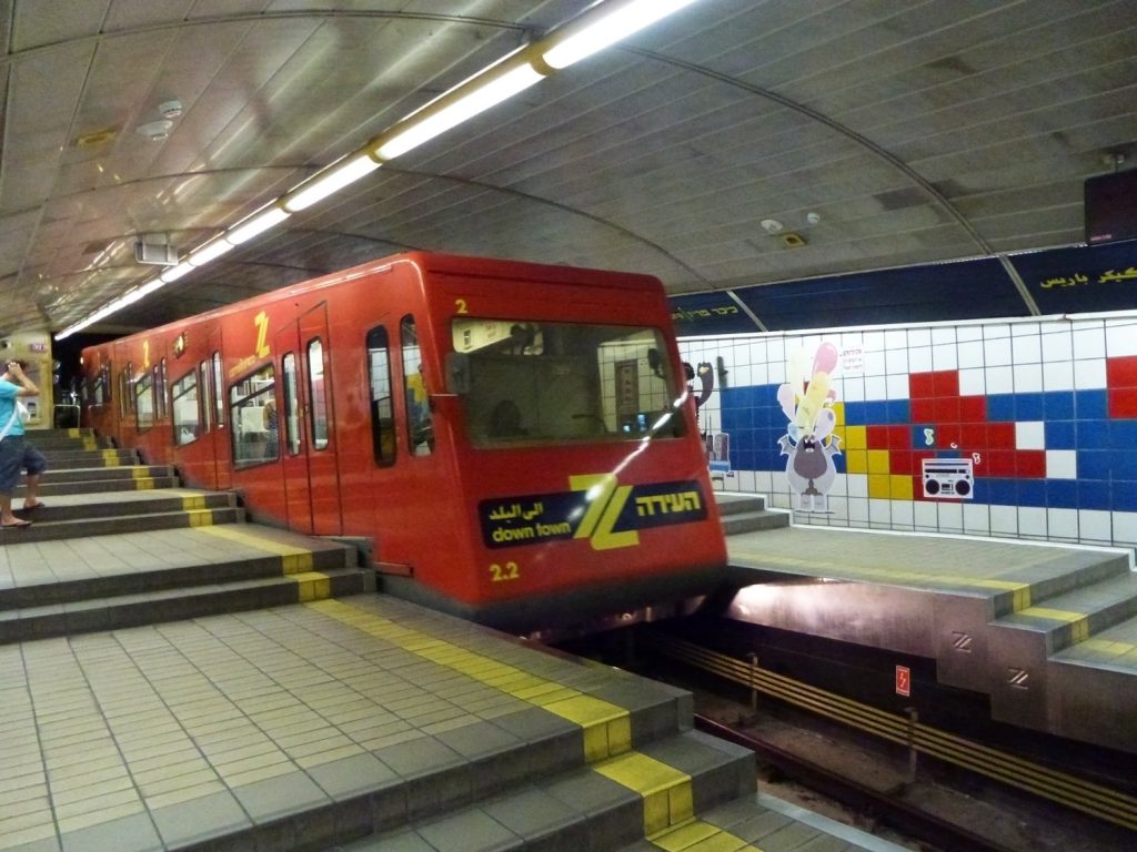 Arrivo del treno alla fermata Paris Square della metropolitana Carmelit di Haifa