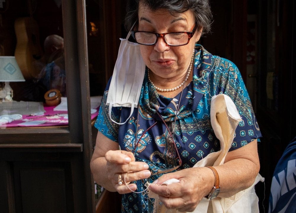 La signora Angela di Varallo Sesia spiega come si realizza il pizzo puncetto valsesiano annodando con precisione il filo di cotone con un ago