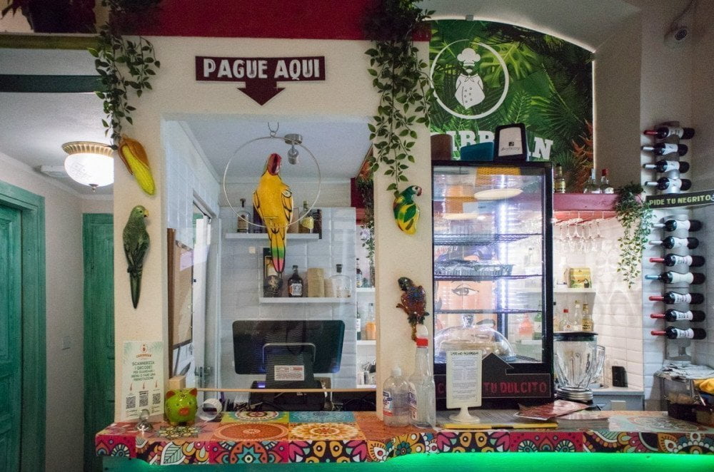 La cassa del Caribbean Bistrot di Torino decorata con un pappagallo finto