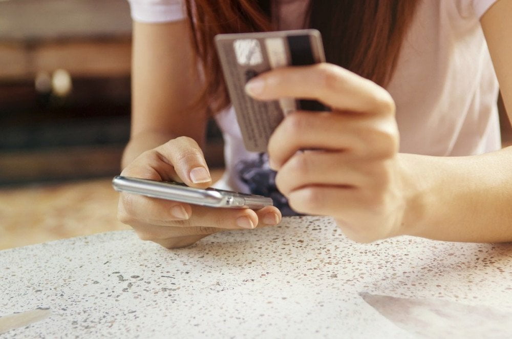 Ragazza con carta di credito e cellulare