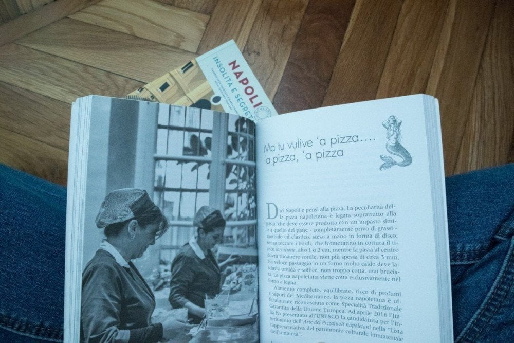 La guida turistica Napoli al femminile di Morellini editore aperta alla pagina della pizza e dietro la guida Napoli insolita e segreta di Edizioni Jonglez