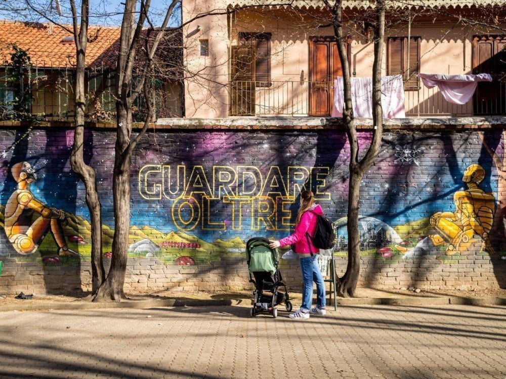 Paola Bertoni davanti a un murales del MAU Museo d'Arte Urbana di Torino, foto Virginia Barinaga Ʌir Fotografía